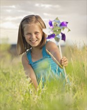 Young girl holding a pinwheel. Photo. Mike Kemp