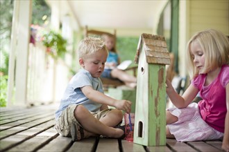 Brother and sister painting birdhouse together. Photo : Tim Pannell