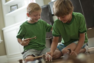 Two boys playing with toy animals. Photo : Tim Pannell