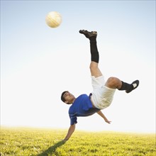 Soccer player jump kicking. Photo : Mike Kemp