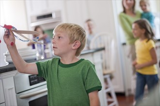 Young boy playing with toy airplane in kitchen. Photo : Tim Pannell