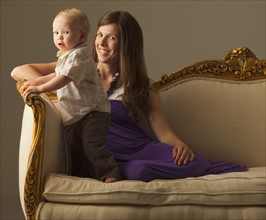Woman and toddler sitting on antique sofa. Photo : Mike Kemp