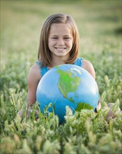 Young girl holding globe. Photo. Mike Kemp