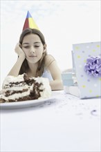 Young girl staring at birthday cake. Photo : momentimages