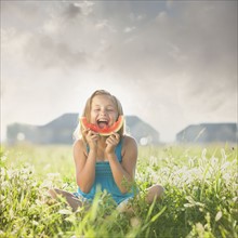Young girl eating a slice of watermelon. Photo : Mike Kemp