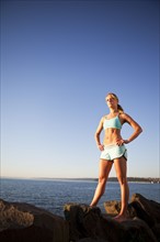Athletic woman standing by the ocean. Photo. Take A Pix Media