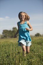 Young girl running in field. Photo. Mike Kemp