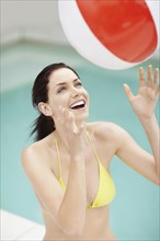 Attractive brunette playing with a beach ball. Photo. momentimages