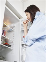 Attractive brunette looking in fridge. Photo : momentimages