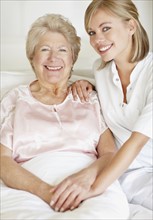 Nurse sitting with a senior woman. Photo. momentimages
