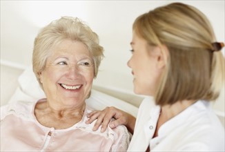 Nurse sitting with a senior woman. Photo. momentimages