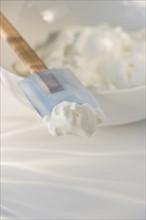 Whipped cream on rubber spatula. Photo. Daniel Grill