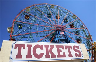 Ferris wheel and tickets sign at fairgrounds. Photo : fotog