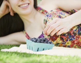 Young woman eating blueberries. Photo. Jamie Grill