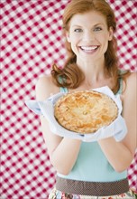 Woman holding a freshly baked pie. Photo. Jamie Grill