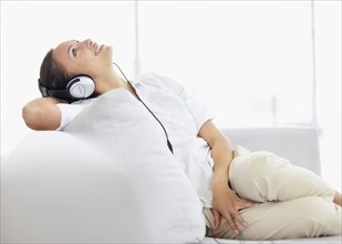 Woman listening to music on headphones. Photo : momentimages