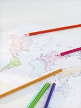 Colored pencils and map of world. Photo : Jamie Grill