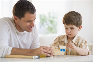 Father and son building a wooden train.