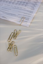 Paper clips and document. Photo : Daniel Grill