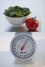 Spinach and tomato on kitchen scale. Photo. Daniel Grill