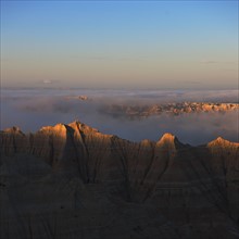 USA, South Dakota, Mountains in morning fog in Badlands National Park.