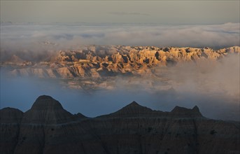 USA, South Dakota, Mountains in morning fog in Badlands National Park.