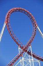Rollercoaster against blue sky. Photo : fotog