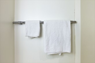 Towels hanging on rail in bathroom. Photo : Jon Boyes
