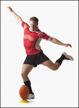 Male rugby player kicking ball. Photo : Mike Kemp
