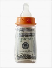 Studio shot of baby bottle with one hundred dollar banknote. Photo : Mike Kemp