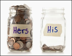 Studio shot of two jars with coins labeled "Hers" and "His". Photo : Mike Kemp