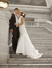 Bride and groom kissing on steps. Photo : FBP