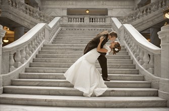 Bride and groom embracing on steps. Photo : FBP