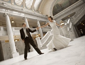 Bride and groom holding hands in mansion. Photo : FBP