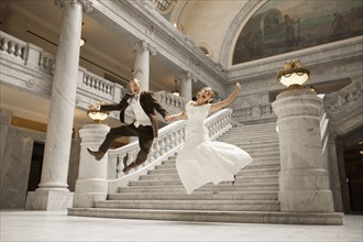 Bride and groom leaping from steps. Photo : FBP
