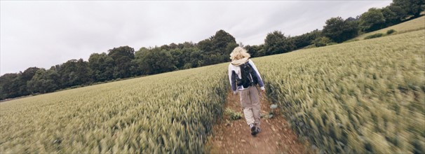 Hiker walking on path through field. Photo : Fisher Litwin