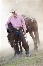 Portrait of senior man with horse in ranch. Photo : Mike Kemp