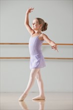 Female ballet dancer (6-7) performing in dance studio. Photo : Mike Kemp