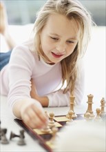 Girl (10-11) playing chess. Photo : Momentimages