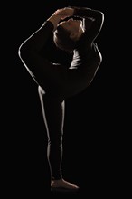 Female contortionist on black background. Photo : Mike Kemp