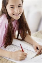 Girl (10-11) doing homework. Photo : Momentimages