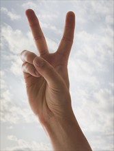 Person's hand showing peace sign. Photo : Mike Kemp