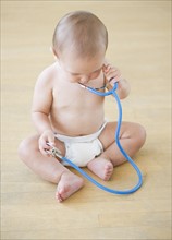 Baby boy (12-17 months) playing with stethoscope. Photo : Daniel Grill