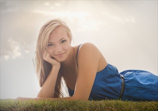 Young girl (16-17) lying on grass. Photo : Mike Kemp