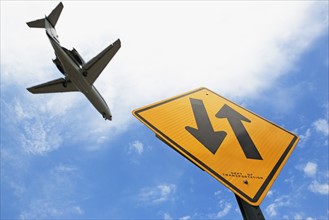 Airplane flying above down traffic sign. Photo : fotog