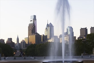 USA, Pennsylvania, Philadelphia, Fountain in Park, Skyline in background. Photo : fotog