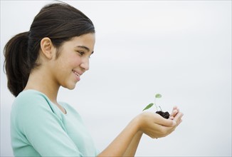 Girl (12-13) holding seedling.