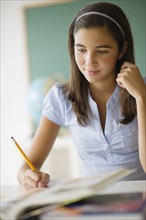 Schoolgirl (12-13) writing.