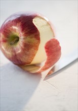 Partly peeled apple, studio shot. Photo : Jamie Grill