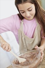 Girl (10-11) preparing food. Photo : Momentimages